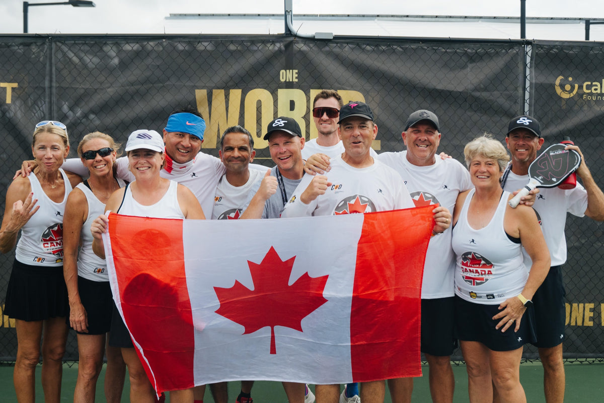 Alex with a pickleball team holding a Canadian flag at a tournament